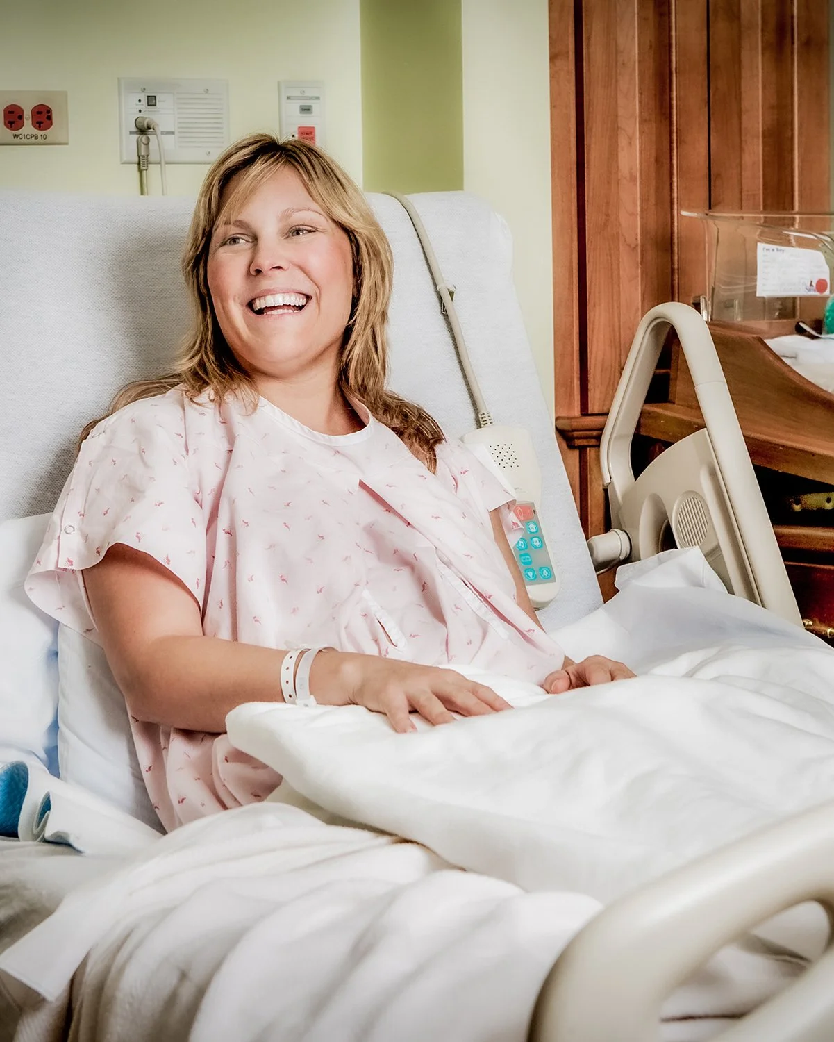 Woman Laughing in Hospital Room after Giving Birth.  Medical Healthcare Photography
