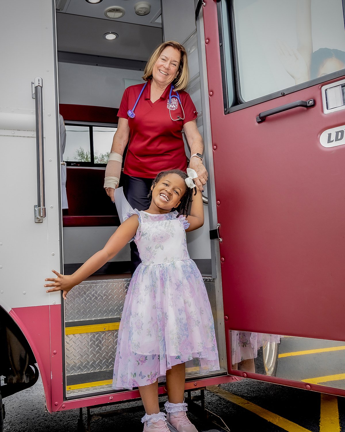 Young African American Girl Leaving a Pediatric Mobile Health Unit with a Healthcare Worker