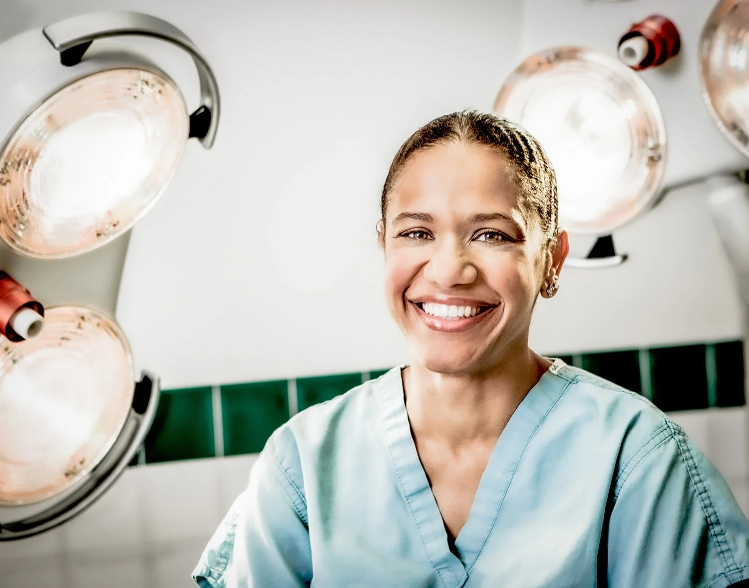African American Female Nurse in front of Large Medical Lights.