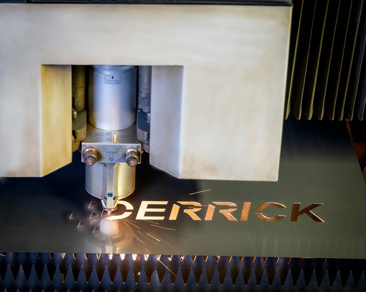Industrial Manufacturing High Tech Machine Laser Cutting the Company Logo out of Sheet Metal.  Industrial Factory Photography