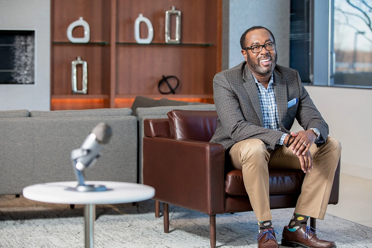 African American Man Smiling in Corporate Setting with a Microphone