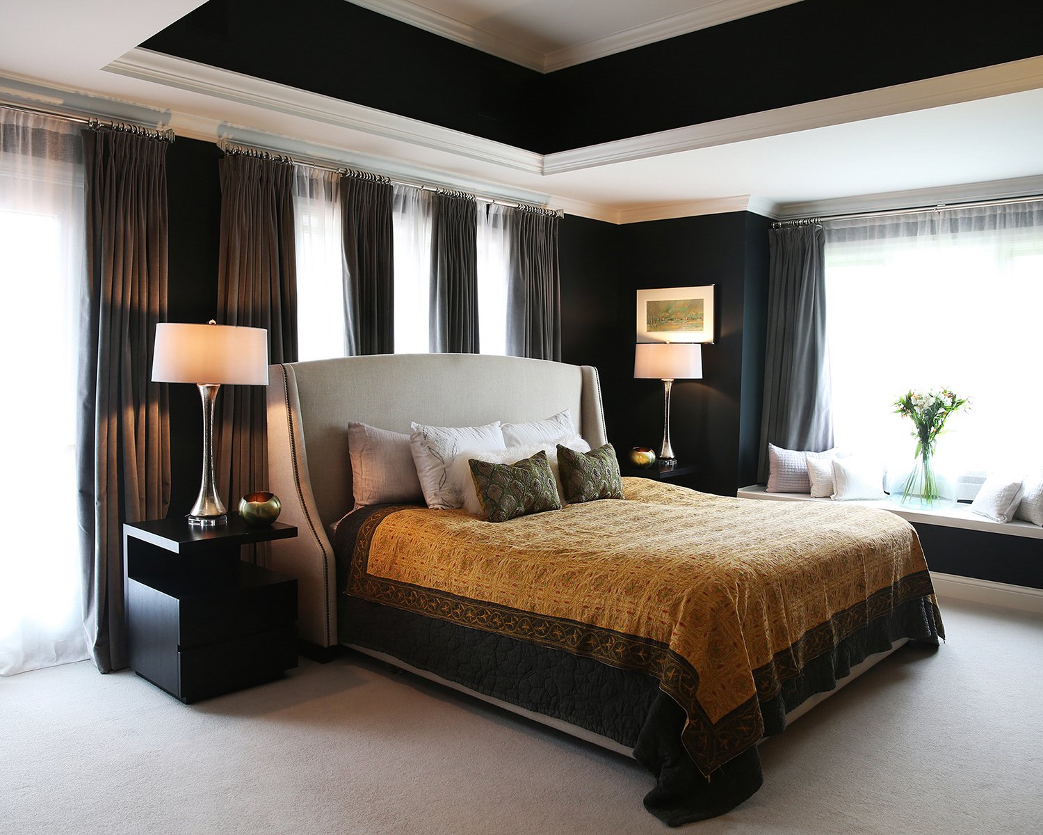 Chicago Interior Photography of a Luxury Bedroom Interior Featuring a Tray Ceiling, Dark Navy Walls, a Tufted Wingback Headboard, and a Gold Patterned Quilt