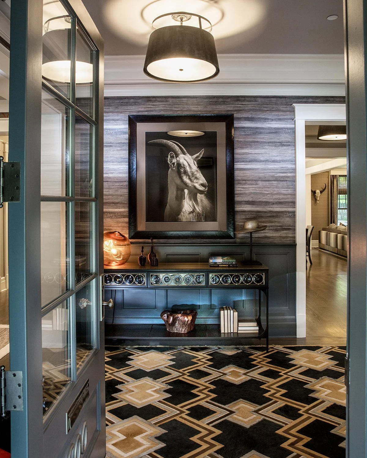 Chicago Interior Photography of a Luxury Foyer Interior with a Large Framed Goat Portrait, Textured Wallpaper, and a Geometric Patterned Rug