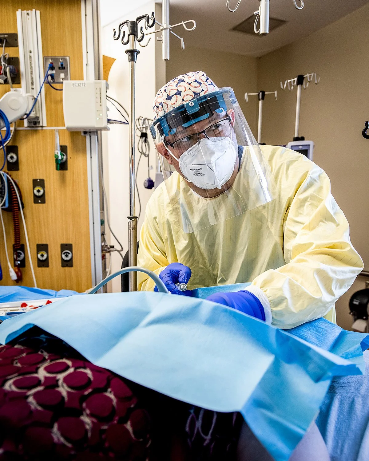 Male Doctor in Scrubs and Full Protective Face Mask Performing a Complex Procedure in the Operating Room