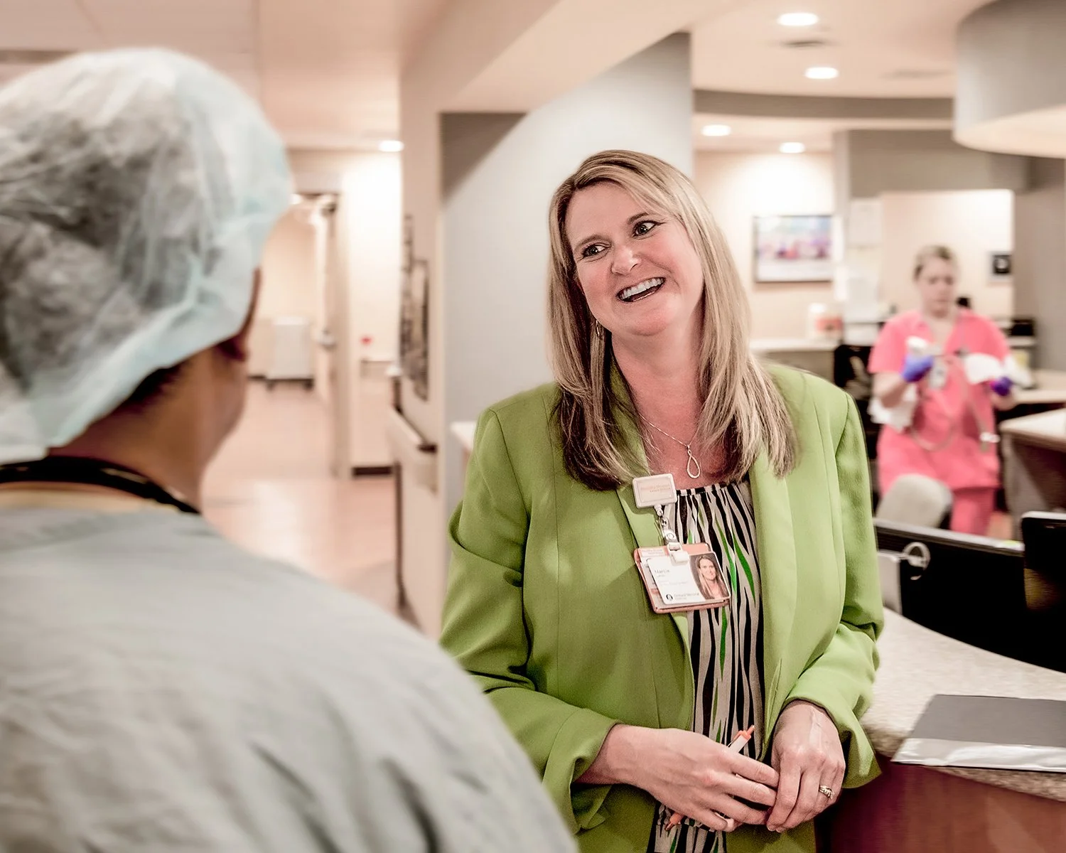 Female Medical Staff Laughing and Talking to Doctor in Hospital Hallway.  Medical Lifestyle Photography