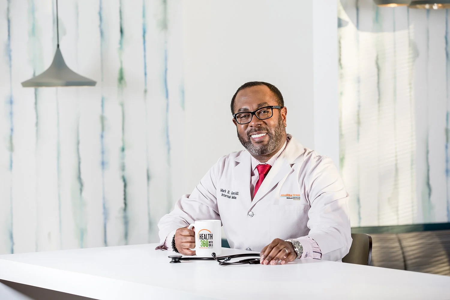 Portrait of African American Male Doctor in Modern Setting Holding a Coffee Mug and Stethoscope