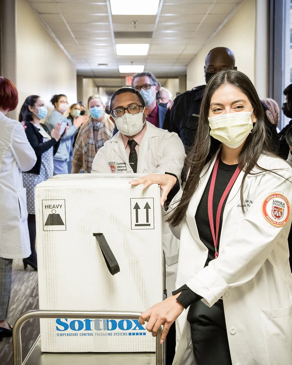 Female Nurse and Male Doctor Rushing Through a Crowded Hospital Hallway to Deliver Covid Vaccines.  Medical Lifestyle Photography