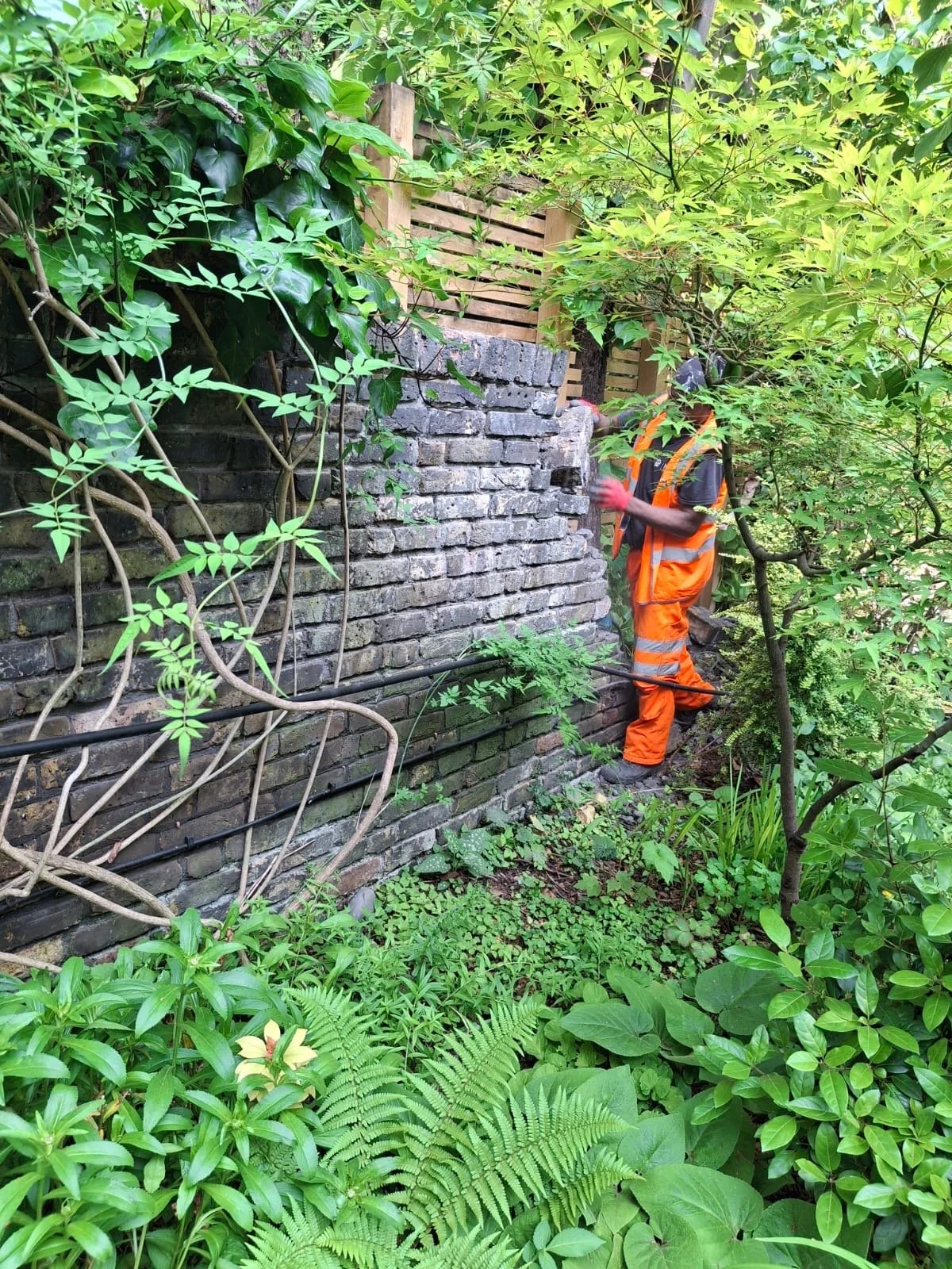 operative-tearing-down-brick-wall-by-hand.JPG