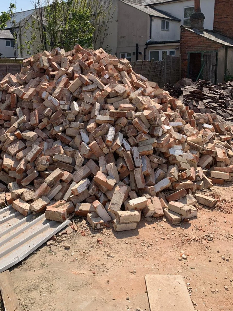 Stacked pile of reclaimed historic bricks sorted for recycling and architectural salvage.