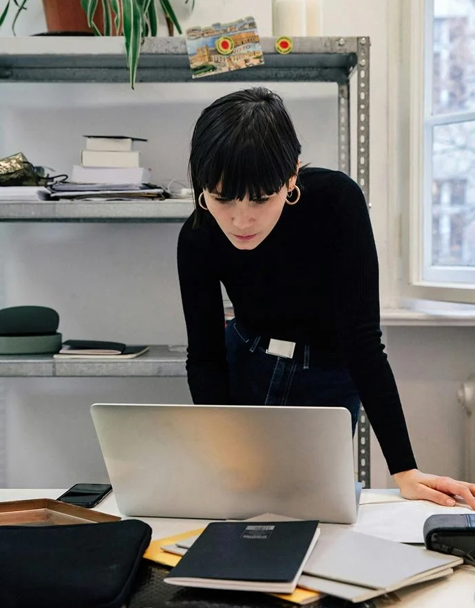 Junge Frau arbeitet an einem Laptop in einem Büro.