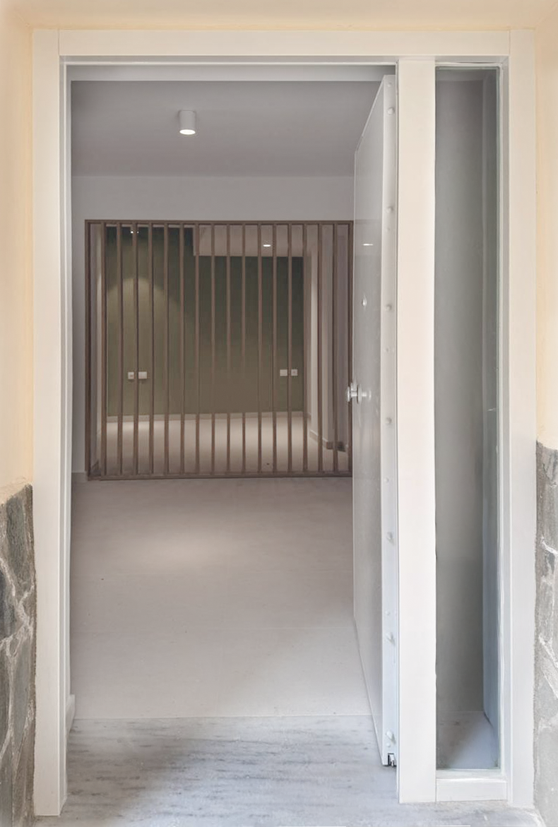 Open door leading into a room with brown vertical slatted partition and gray walls.