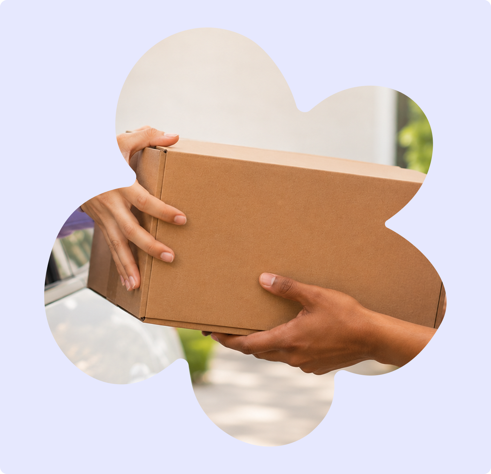 Two people are exchanging a cardboard box outdoors, with trees and a building in the background.