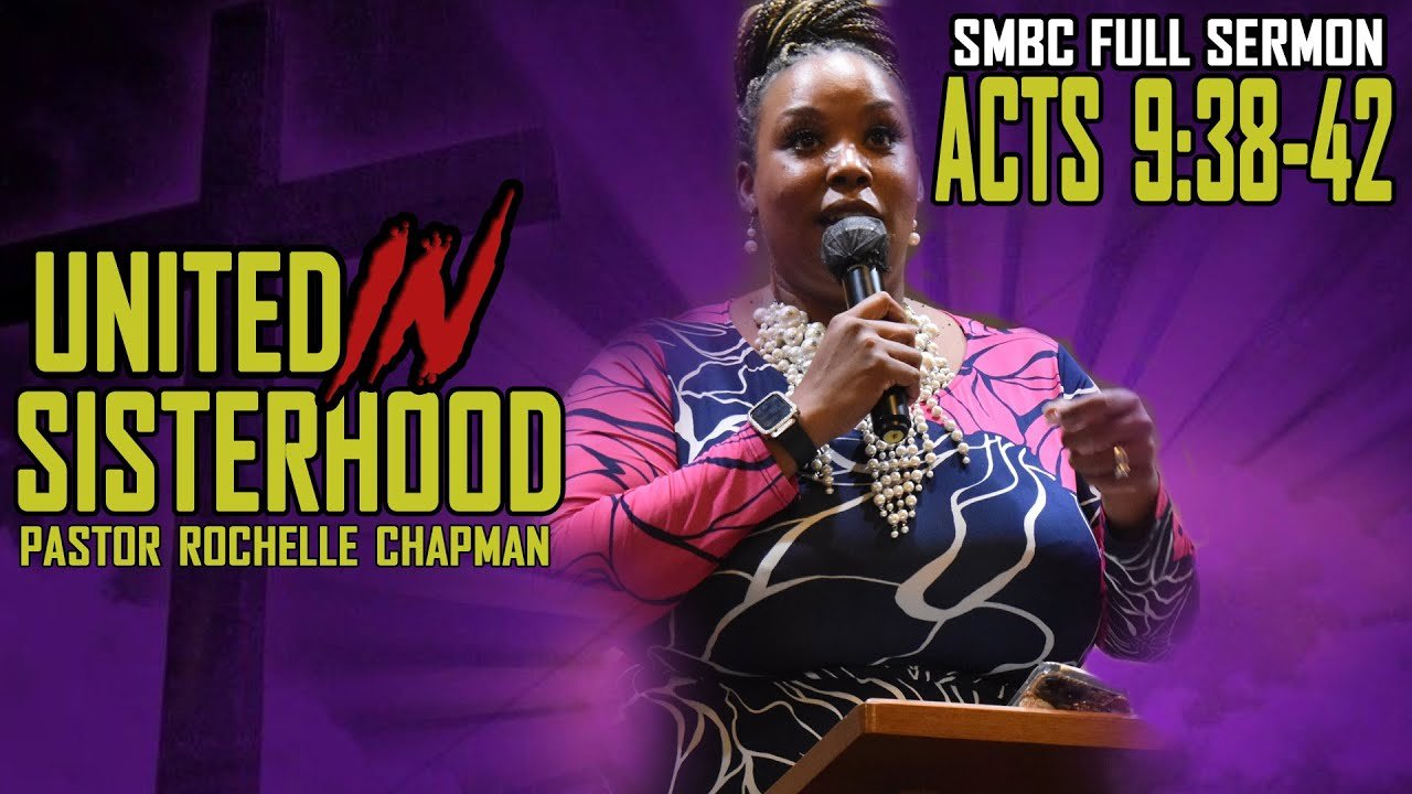 A woman speaking into a microphone at a church service, with a purple background and a cross. The text reads: 'SMBC Full Sermon Acts 9:38-42', 'United in Sisterhood', and 'Pastor Rochelle Chapman'.