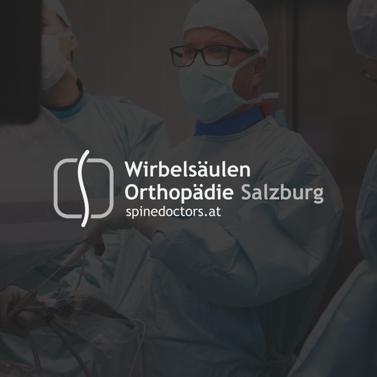 Ärzte in Operationssaal mit Schutzkleidung und Masken, die eine Wirbelsäulenoperation durchführen.