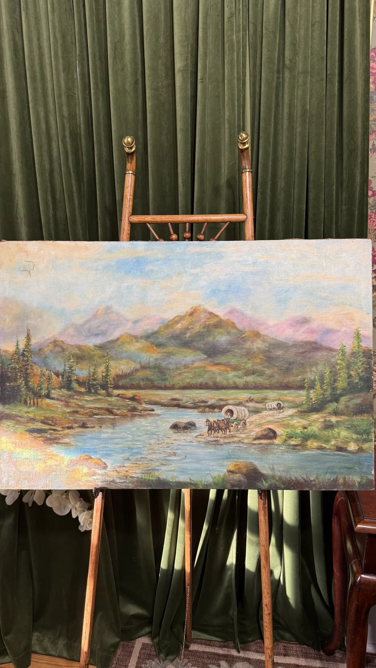 Landscape painting of a river with trees and mountains in the background, with a wagon and horses crossing the river.