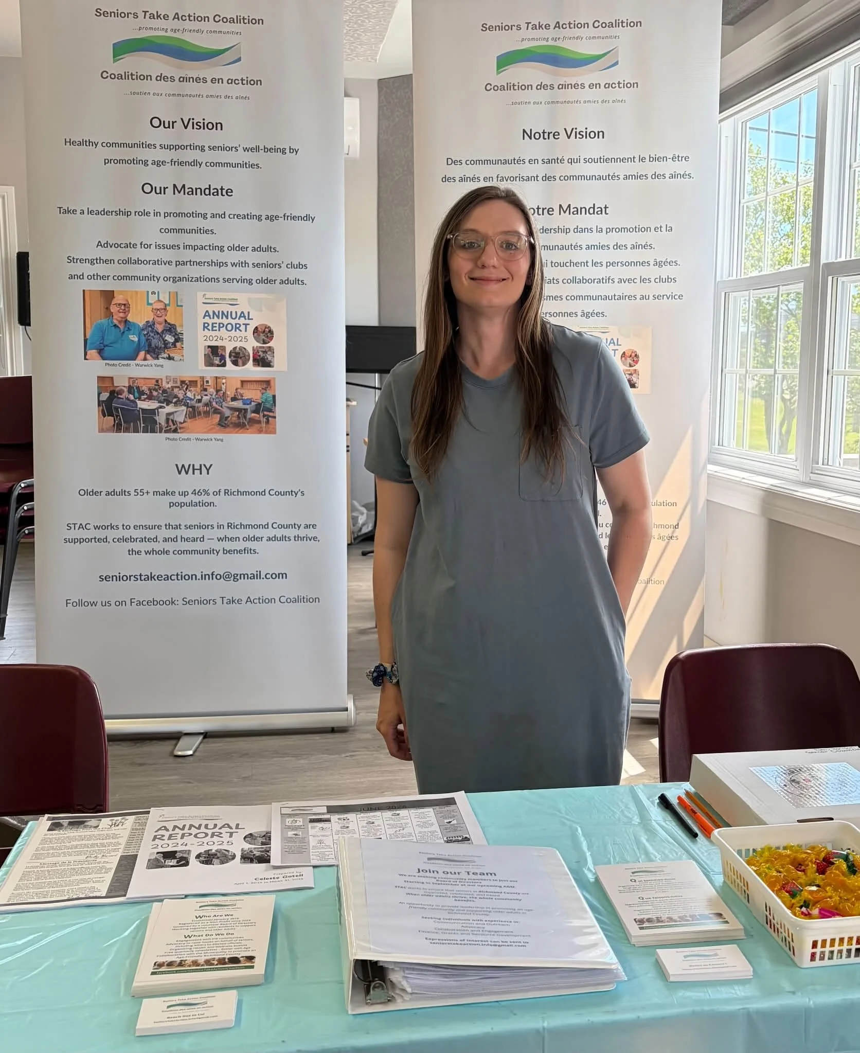 Celeste Gotell standing at the STAC information booth with banners and brochures