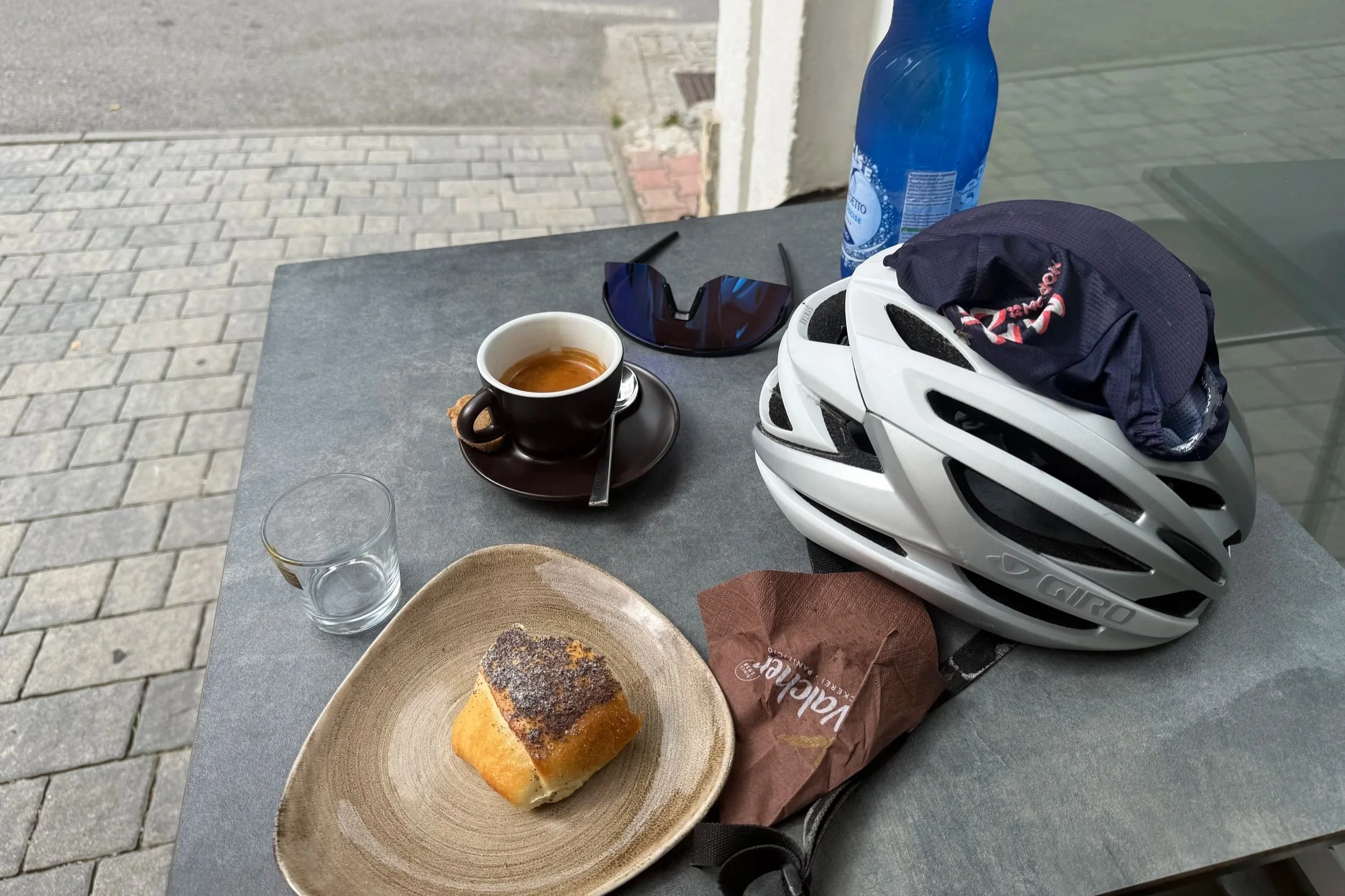 Pause während der Bikepacking-Tour mit Kaffee, Gebäck und Fahrradhelm auf einem Tisch