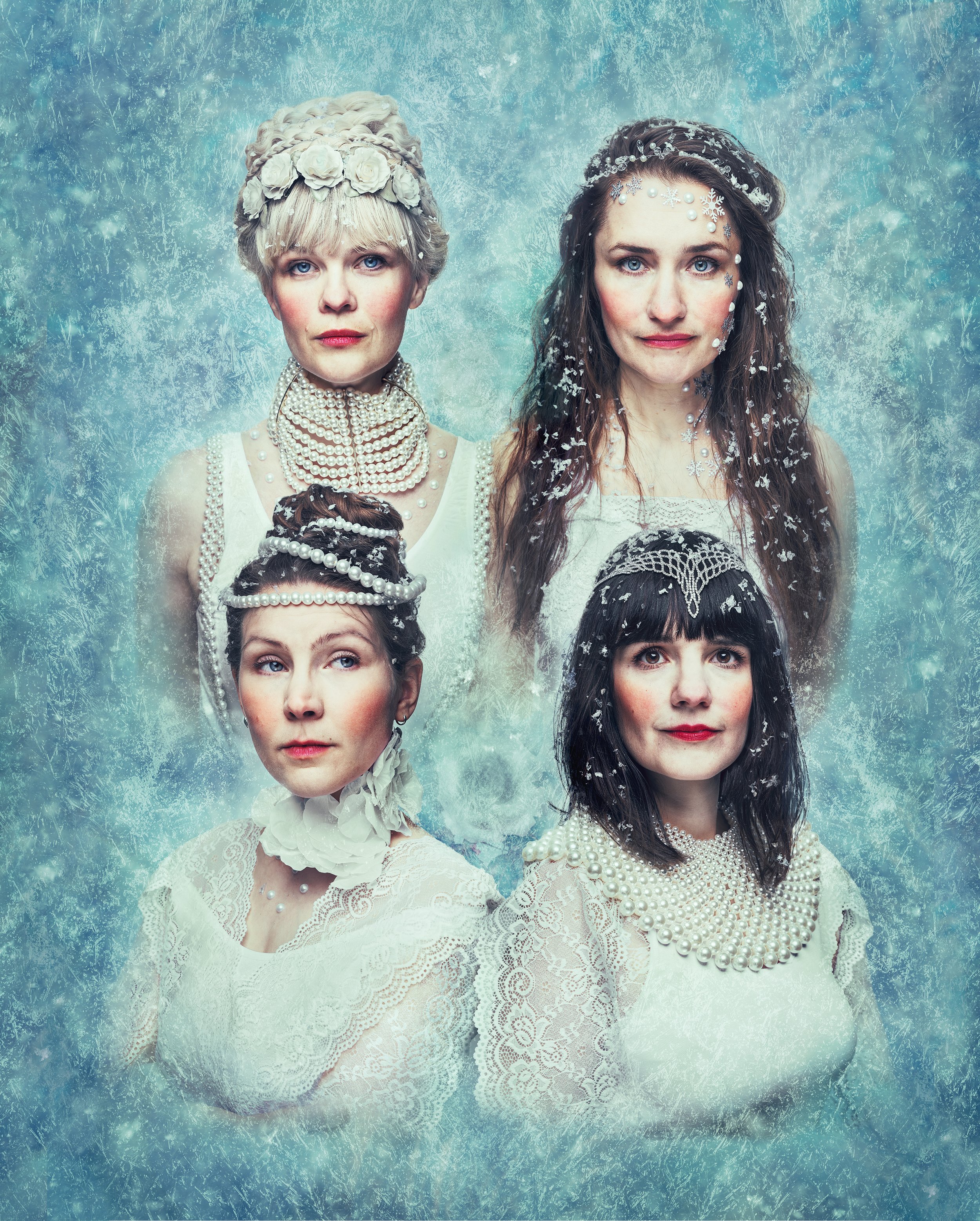 Portrait of four women dressed in ornate white dresses with pearl accessories, set against a frosty blue background with snowflake patterns.