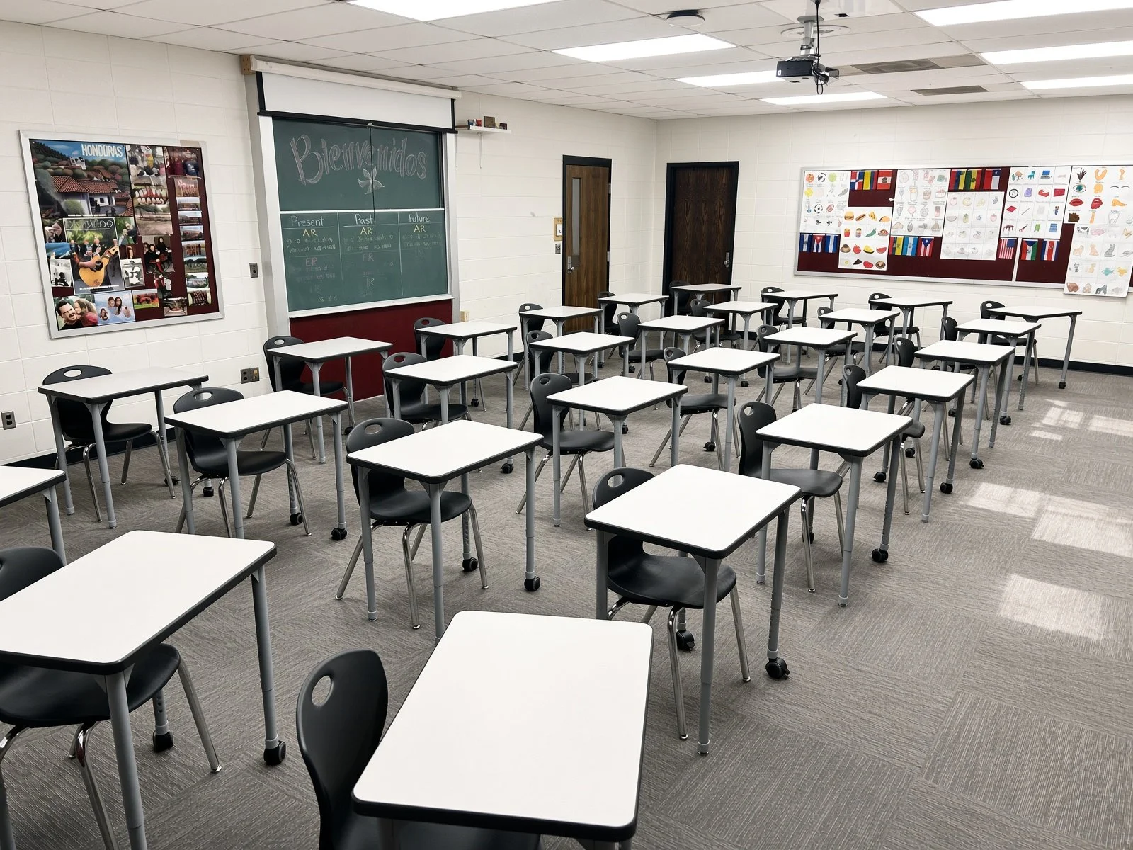 Classroom with white desks and black chairs and educational posters on the walls.  Expertly installed and staged classroom furniture.