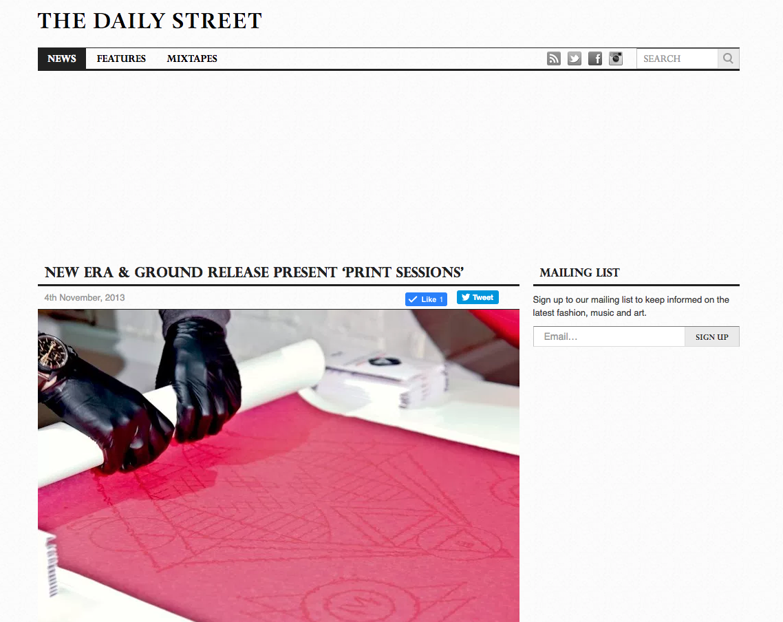A person wearing black gloves is handling a large sheet of pink fabric with a design drawn on it. The fabric is laid out on a table, and the person is holding a white cylindrical object.