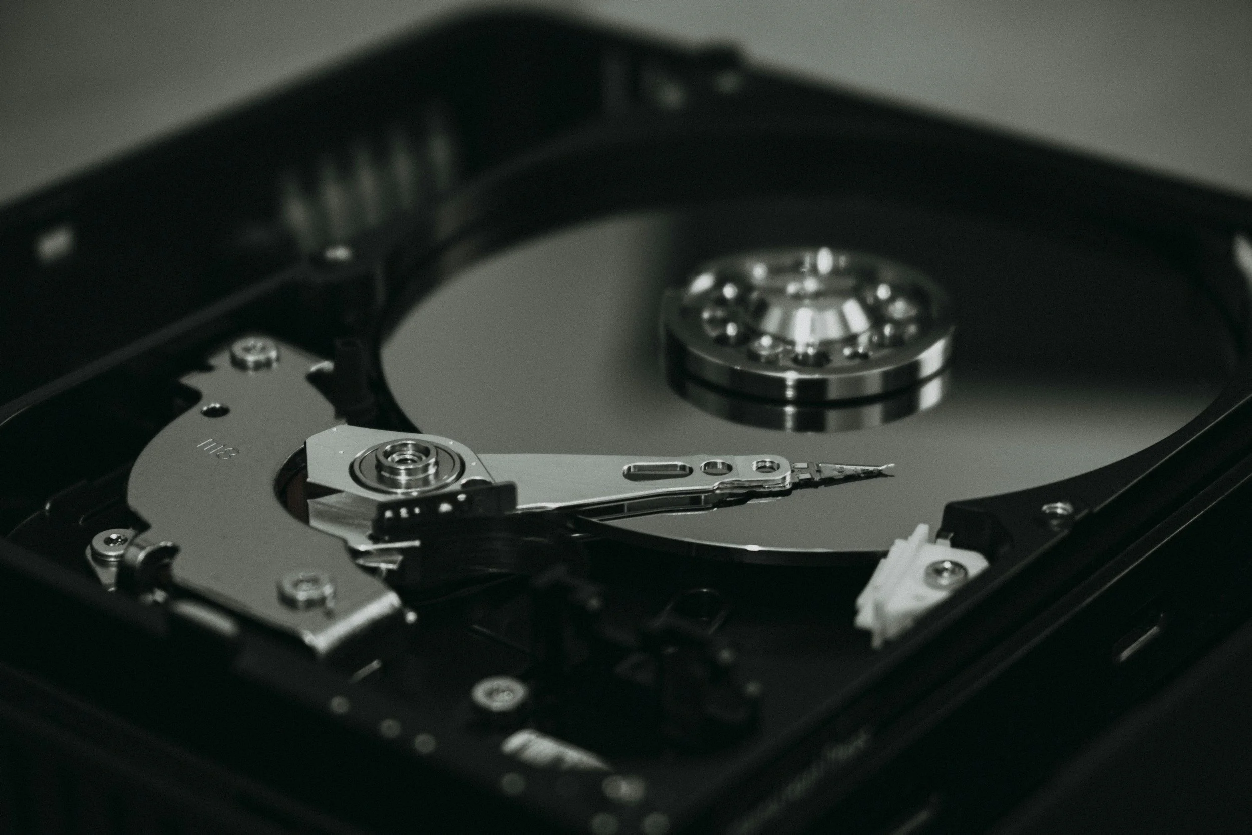 Close-up of an internal hard drive with exposed spinning disk and mechanical components.