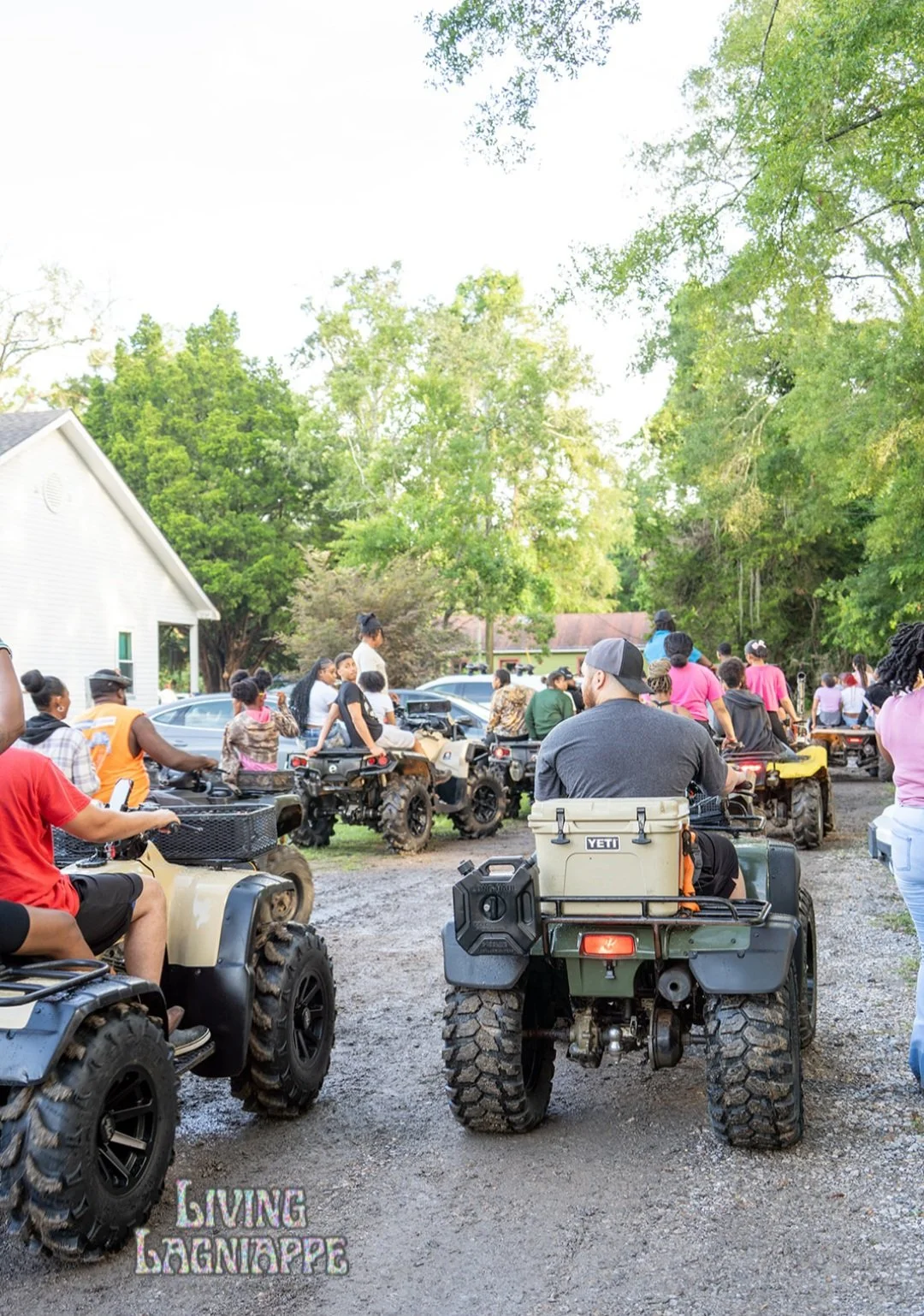 Families and neighbors gathering for four-wheeler rides at an outdoor community event.