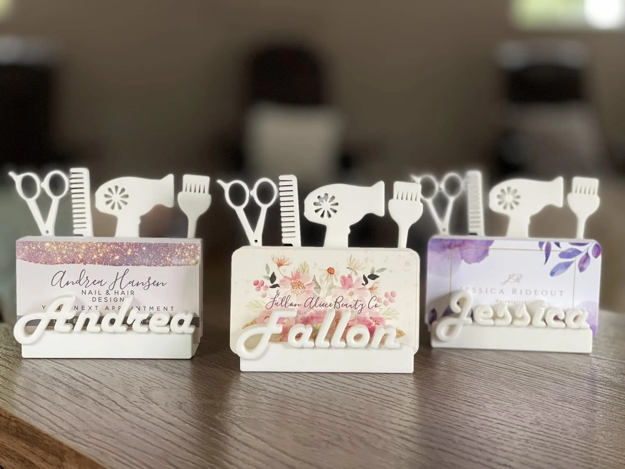 Decorative table signs with names Andrea Hansen, Fallon Alice Beauty Co., Jessica Rideout, placed on a wooden surface.