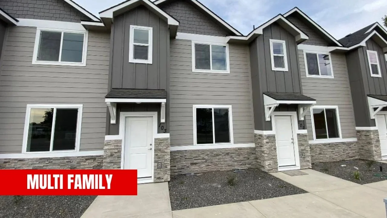 A row of modern townhouses with gray siding, stone accents, and white trim, featuring multiple windows and small front porches. The caption reads 'MULTI FAMILY.'