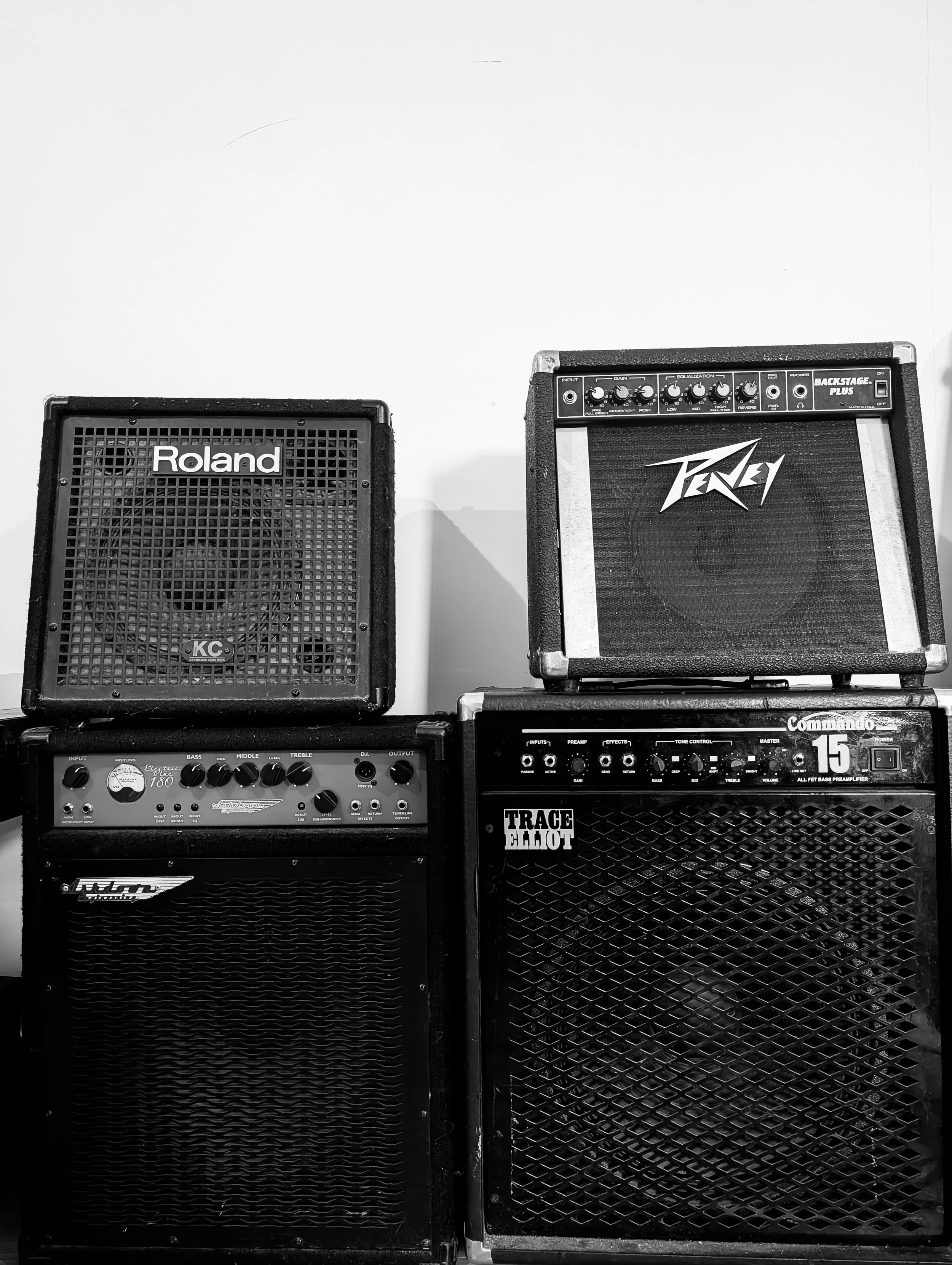 Two guitar amplifiers stacked on top of each other. One on the left branded 'Roland', and the other on the right branded 'Peavey' with additional controls and labels visible at the top.