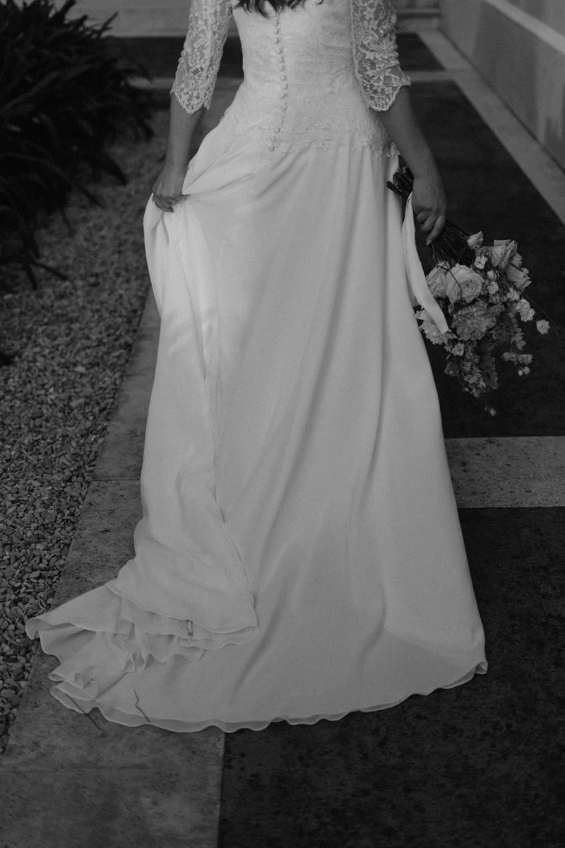 A woman in a wedding dress holding a bouquet of flowers.