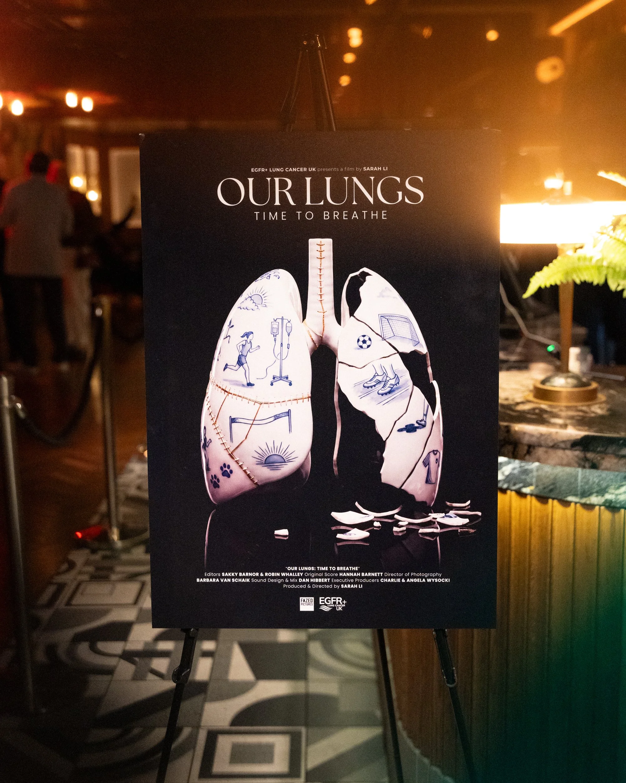 Poster for a film titled 'Our Lungs: Time to Breathe', showing a pair of lungs with various illustrations including sports, medical instruments, and nature scenes, set in a dimly lit indoor space.