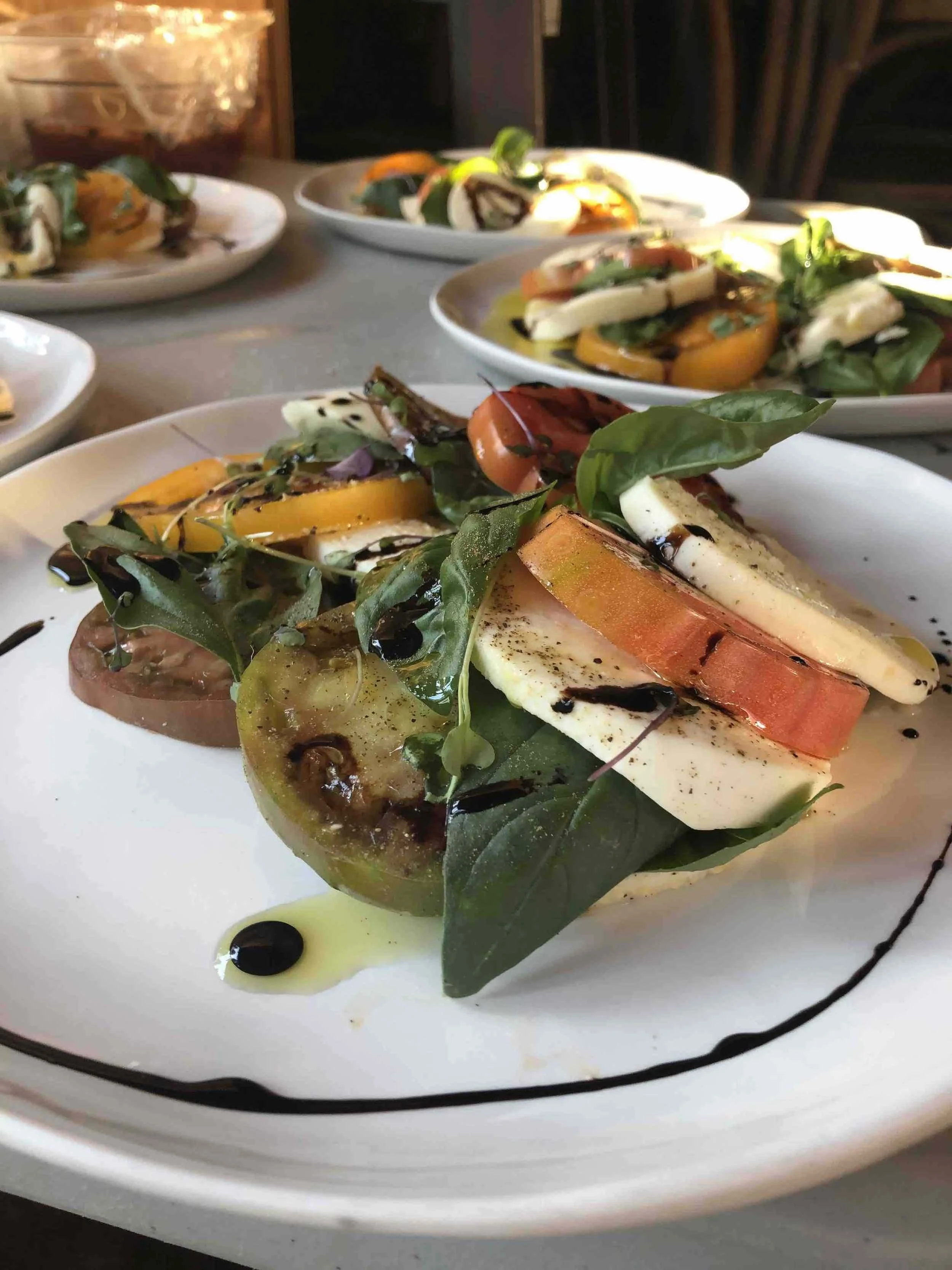 Heirloom tomato and fresh mozzarella Caprese salad with basil and balsamic glaze, prepared by a private chef Utah for an elegant dinner.