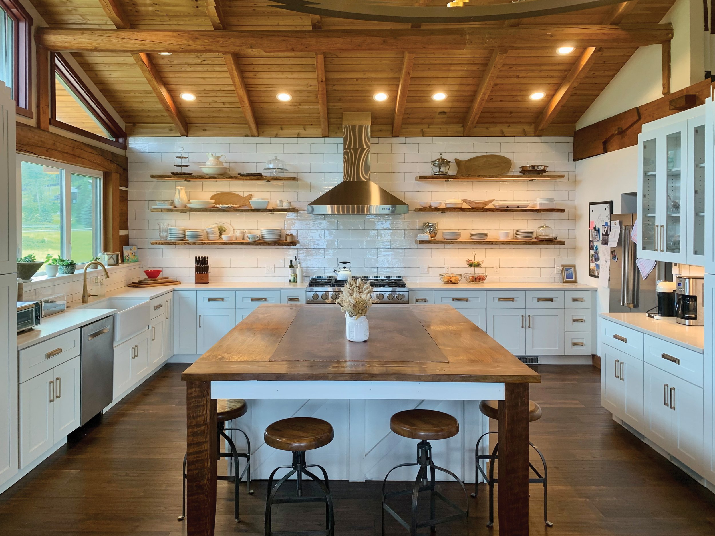 Beautiful and brigth renovated kitchen with white cabinetry and tile work with warm wooden accents.