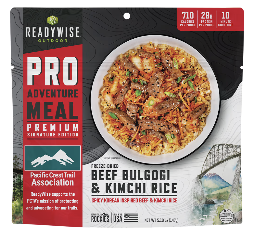 Package of ReadyWise outdoor freeze-dried beef bulgogi and kimchi rice, served on a white plate, with a colorful mix of sliced beef, rice, kimchi, and vegetables.
