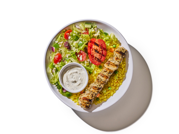 Plate with salad, grilled chicken skewer, rice, and salad dressing