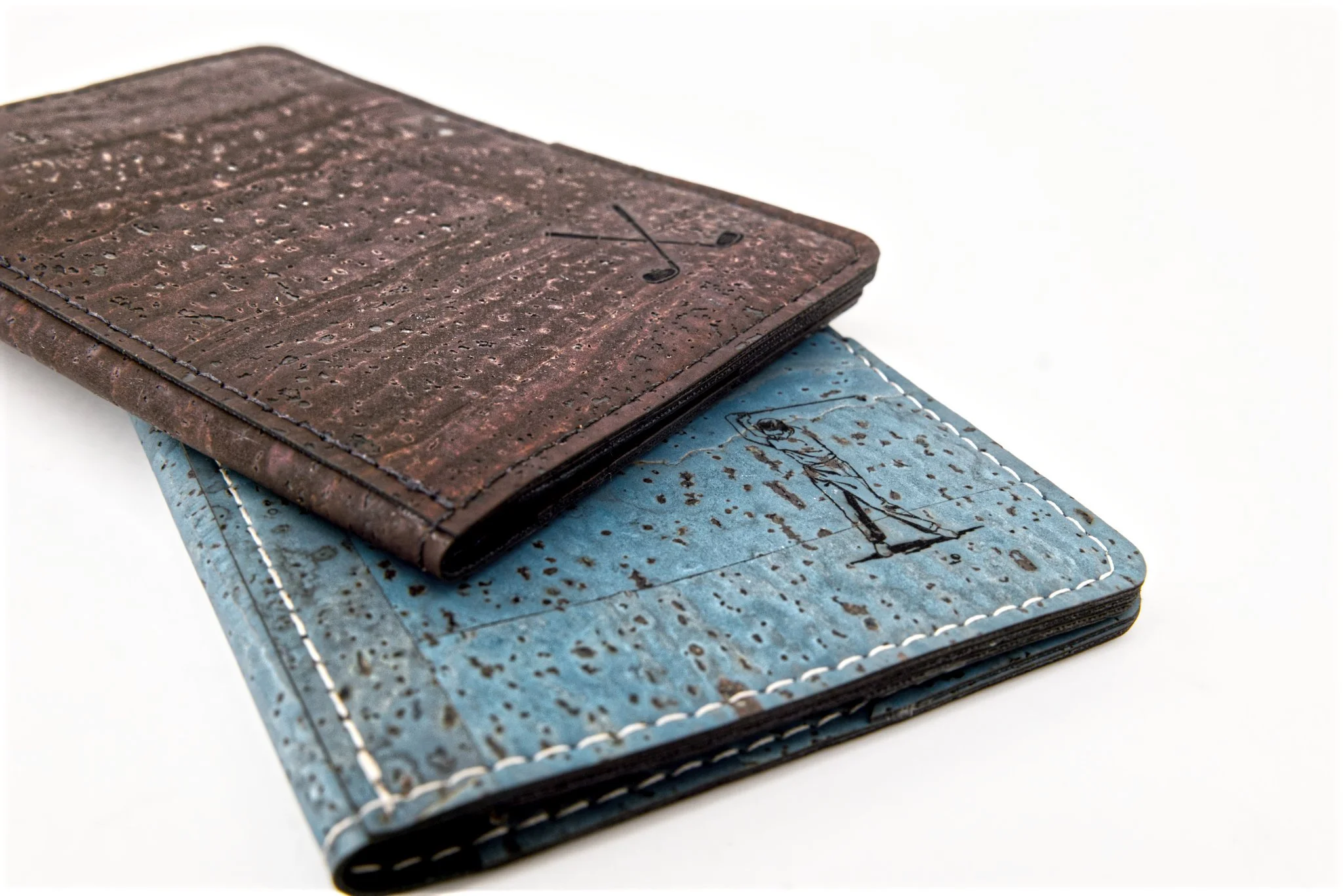 Close-up of two small leather-bound notebooks, one brown and one blue, stacked on each other with leather covers and embossed designs.
