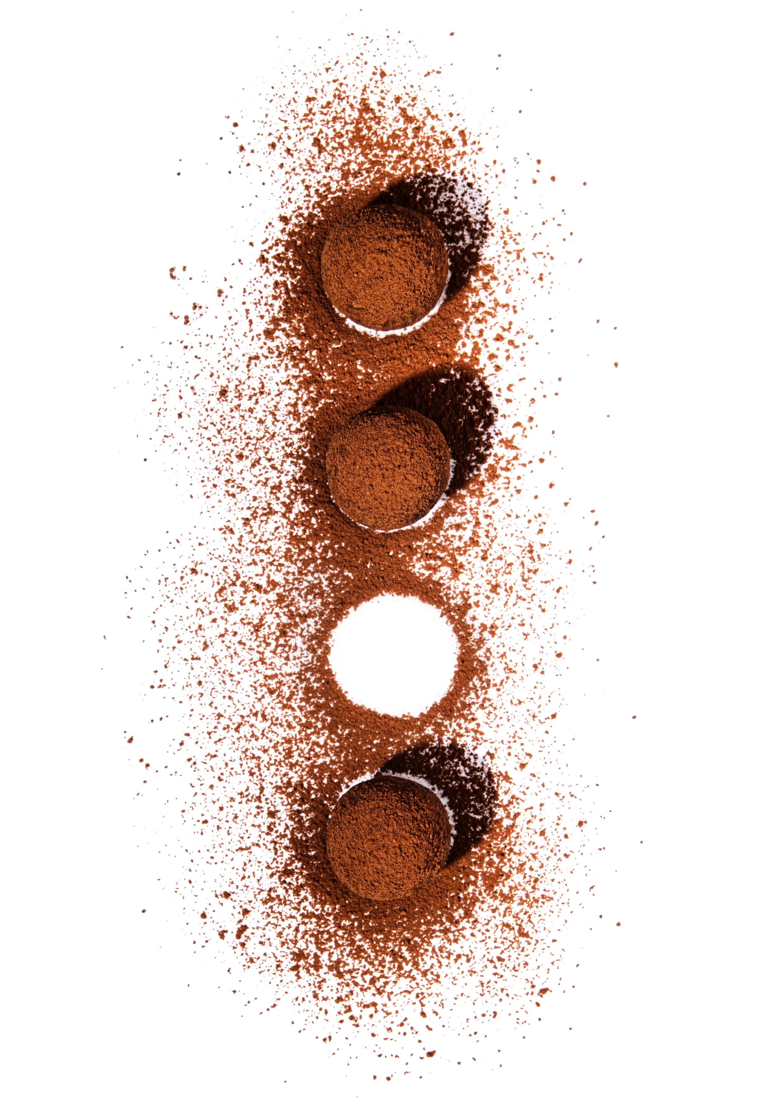 Top view of brown powder and spherical balls arranged in a vertical line on a white background.