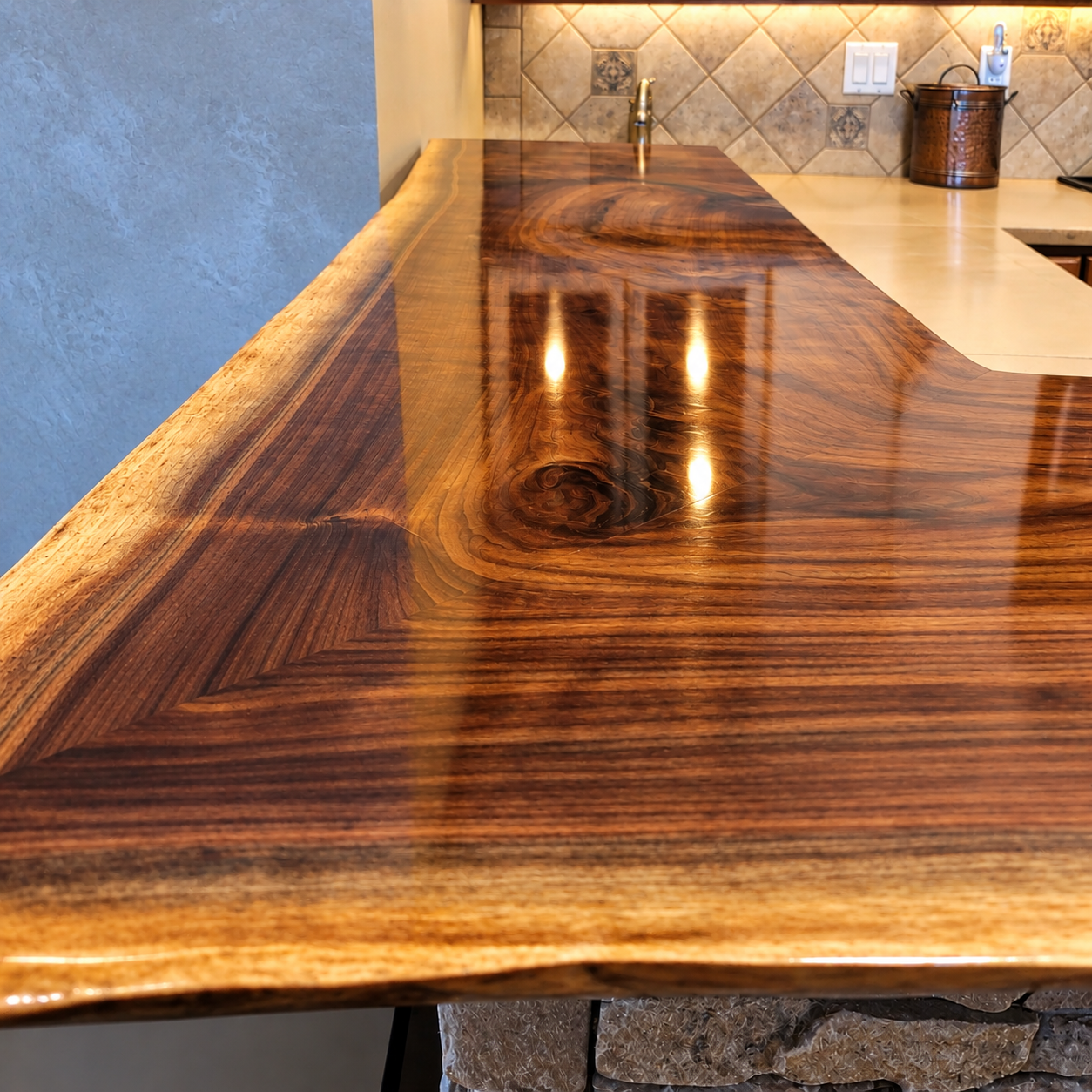 Close-up of a polished wooden kitchen countertop with visible wood grain and a glossy finish.