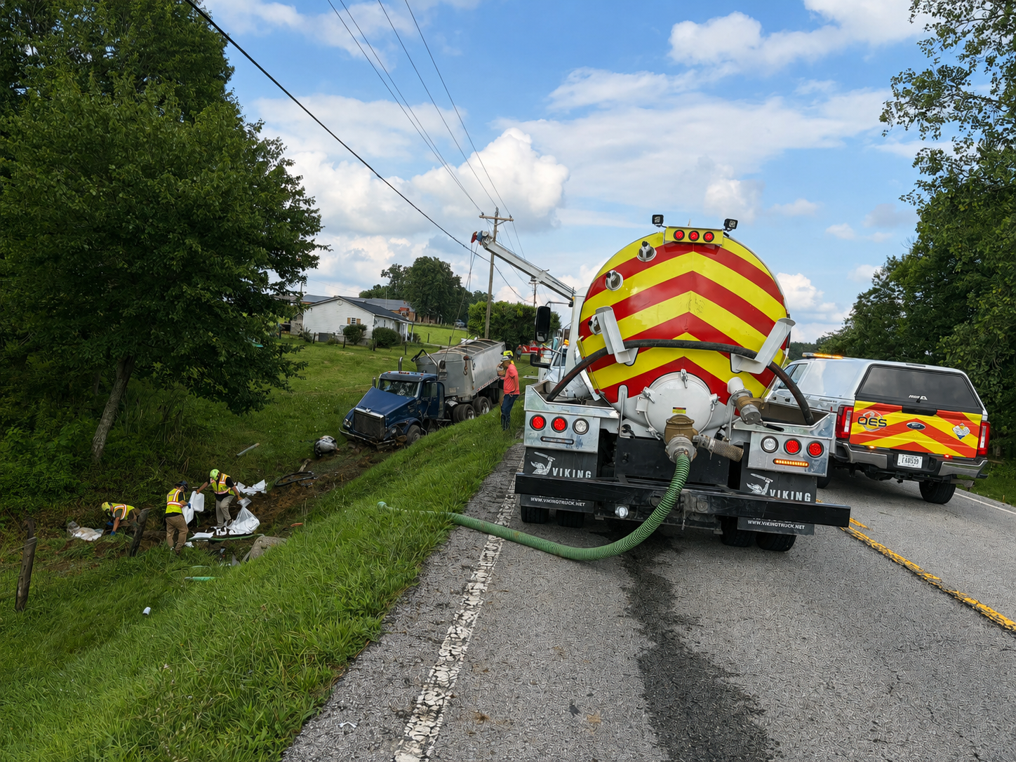 OES field crew and response equipment at a roadside environmental cleanup scene.