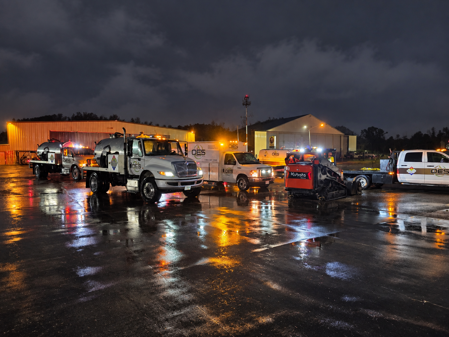 OES environmental response vehicles and specialized equipment staged for field operations at night.