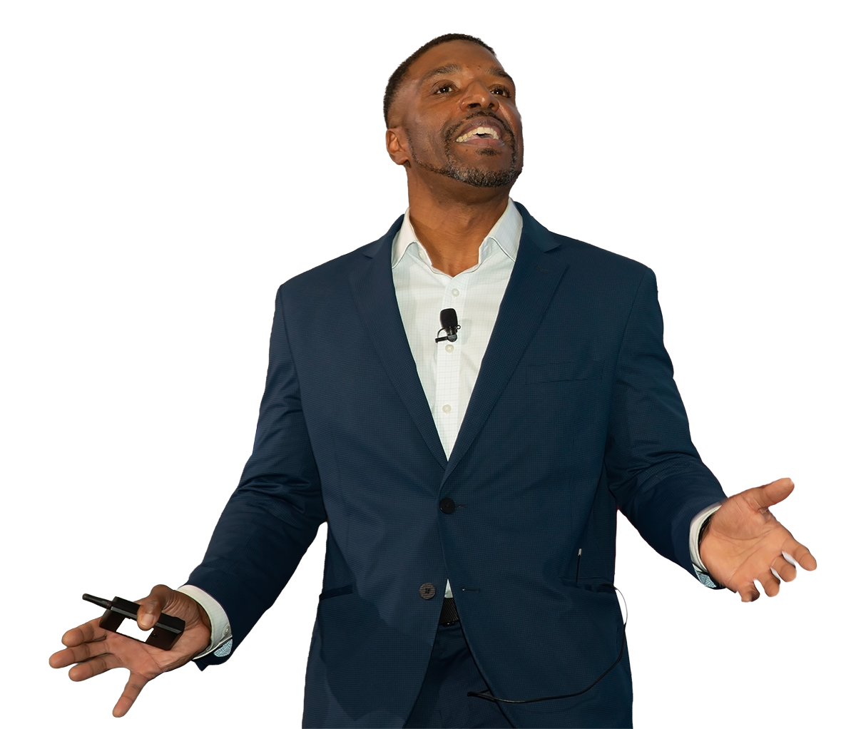 Man in dark suit giving a presentation with a clicker in his left hand and gesturing with his right hand.