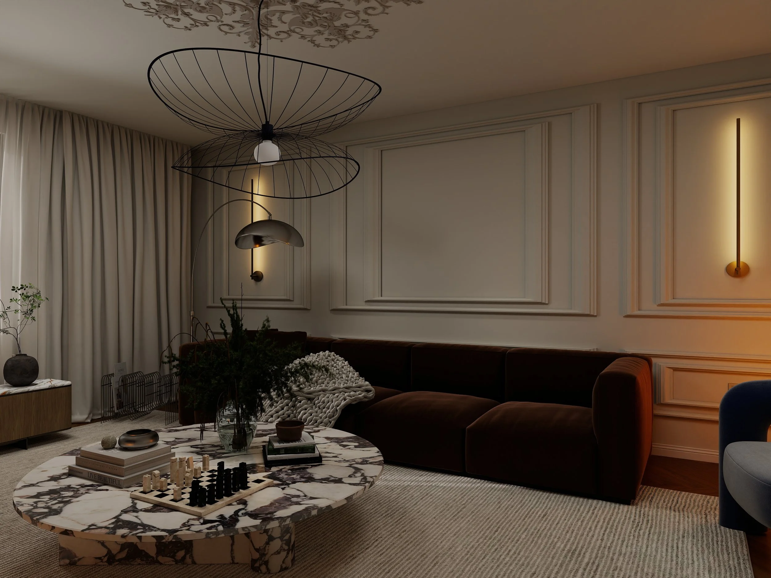 Living room with a white marble coffee table, a brown sofa with a textured blanket, and a mix of modern and traditional light fixtures on beige walls.