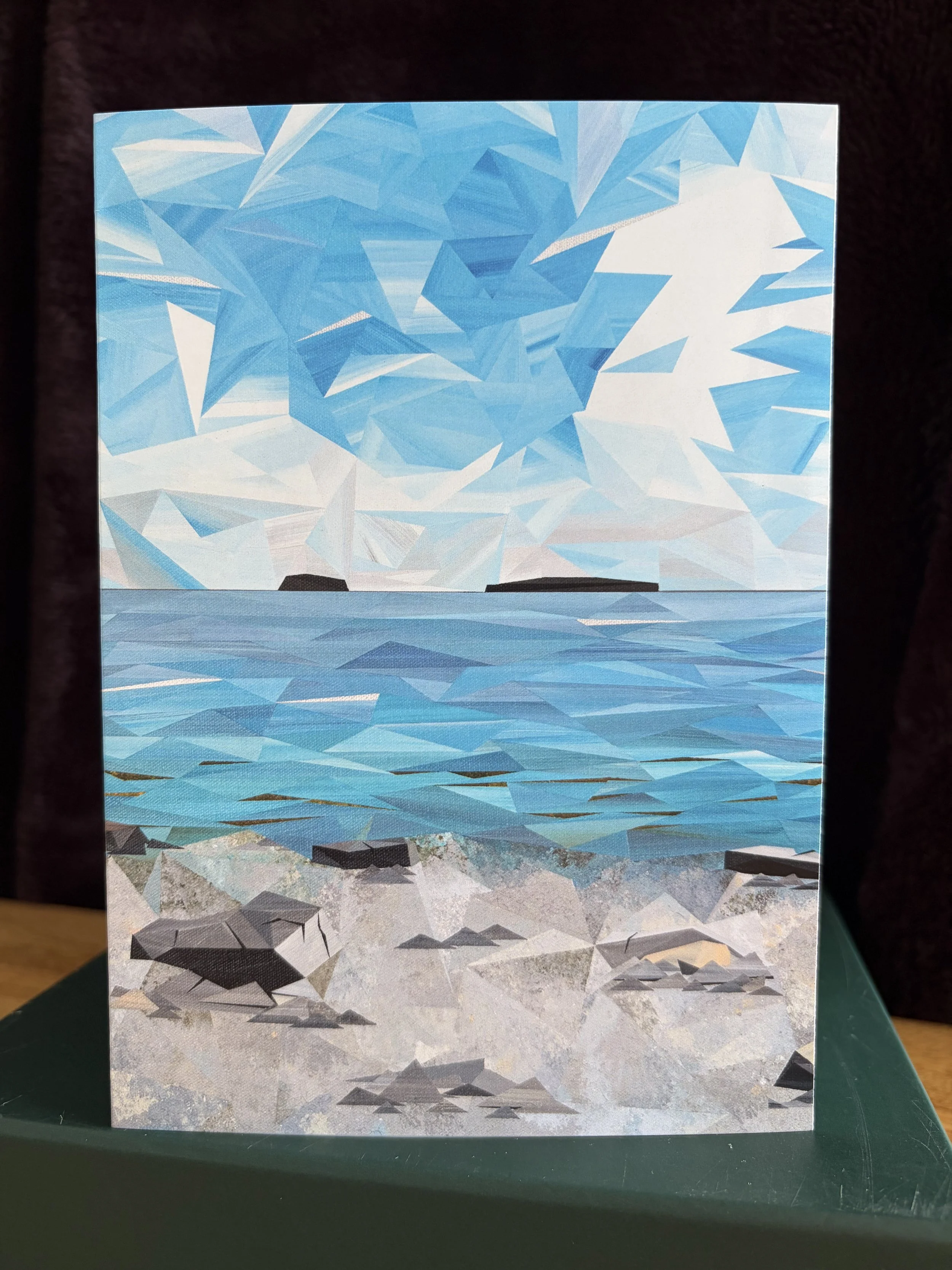 Lepreau greeting card, featuring Marilyn Calleja’s New Brunswick coastal landscape with blue water, rocky shoreline and a bright geometric sky.