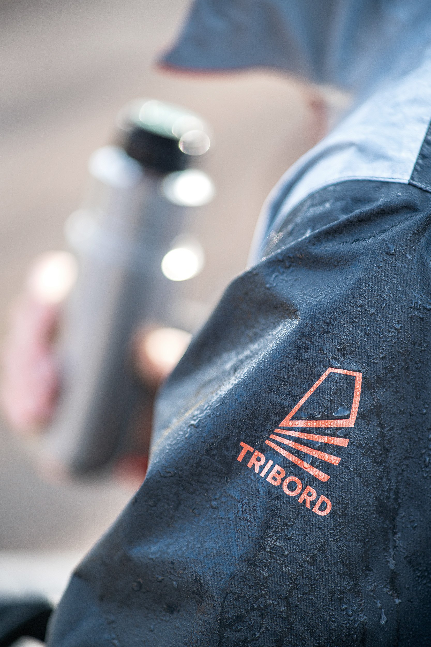 Nahaufnahme eines stark verschmutzten Motorradhandschuhs mit dem Logo 'TRIBORD' auf der Oberseite.