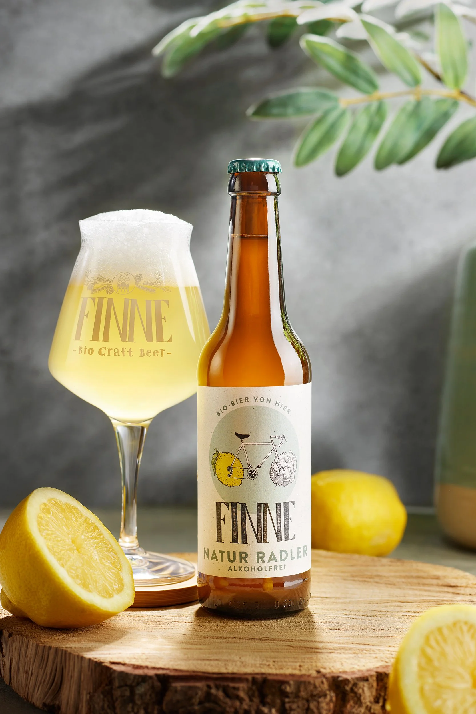 Bierflasche und Weinglas mit Zitronen auf einem Holzblock