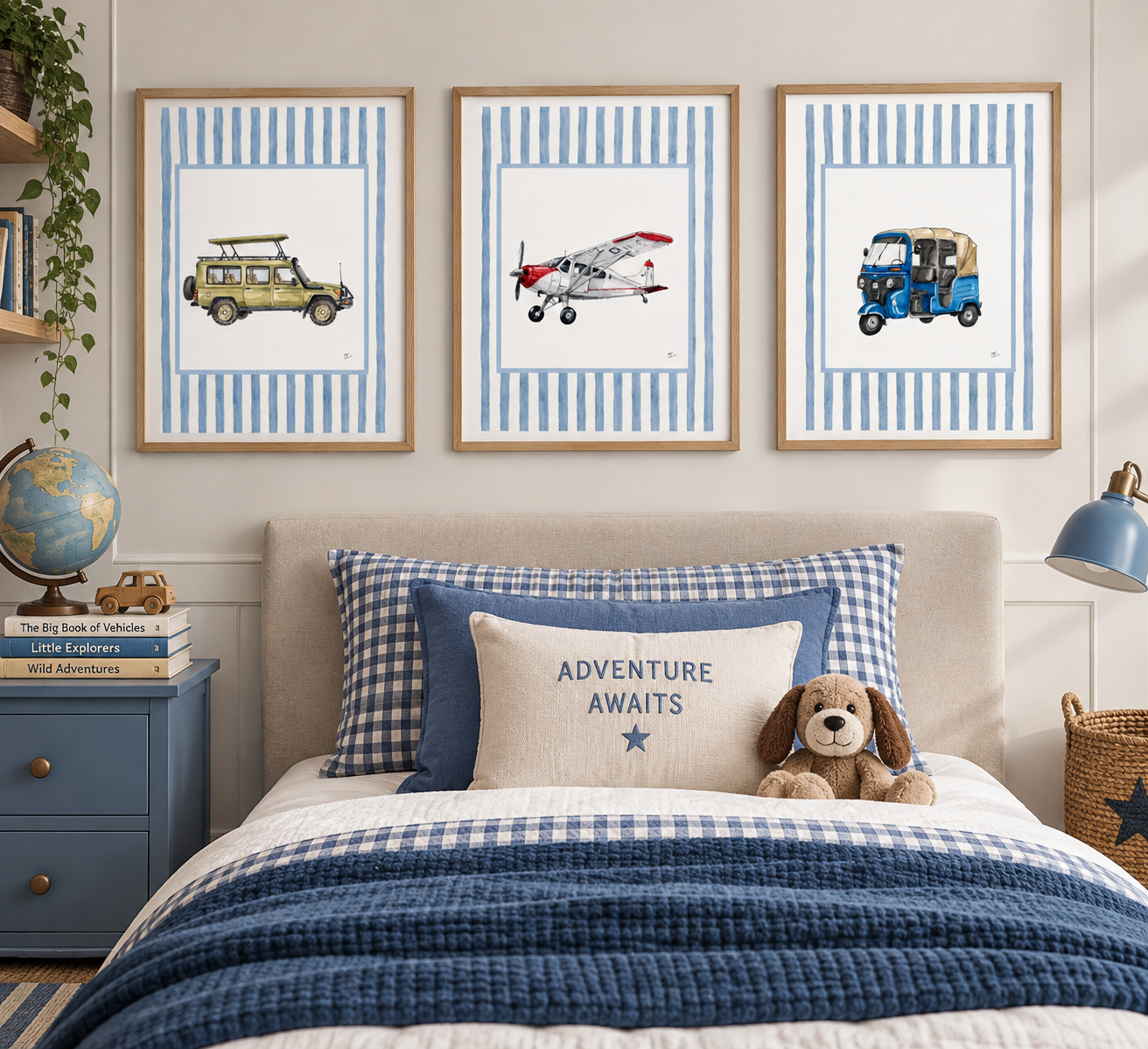 A bedroom with three framed pictures of vehicles on the wall above the bed: a yellow off-road vehicle, a red and white airplane, and a blue three-wheeled auto rickshaw. The bed has blue and white gingham and solid blue pillows, and a beige pillow with the words "Adventure Awaits" and a star. There is a stuffed dog on the bedding. To the left, a blue nightstand holds a globe, a few books, and a small wooden car. To the right, a wicker basket and a blue lamp are visible.