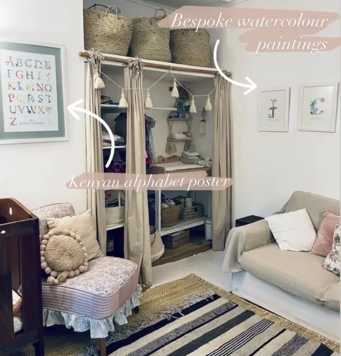 Decorative interior room with framed alphabet poster on the left wall, watercolour paintings on the right wall, a cozy armchair with textured pillows, and a beige sofa with a pink pillow. An open wardrobe with curtains and baskets above, and a rattan rug on the floor.