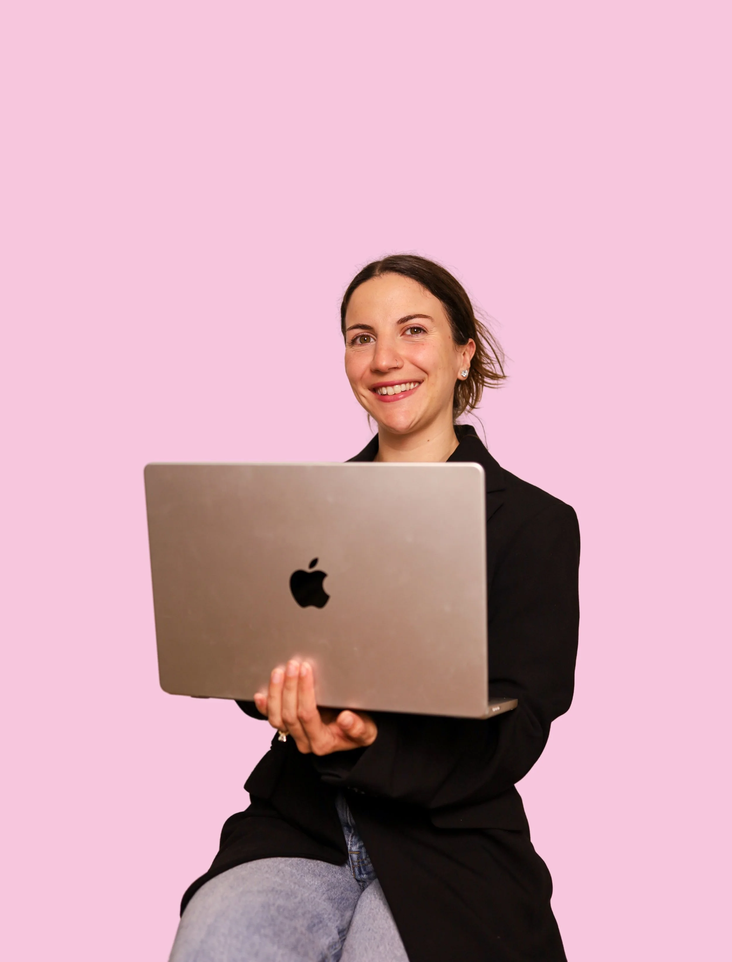 Camila Retnauer, Long Island real estate agent, holding a laptop