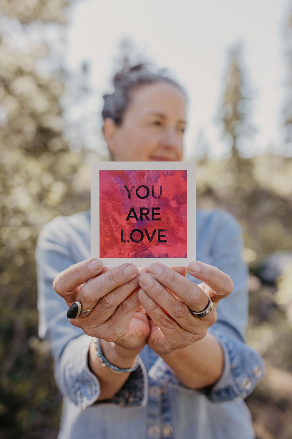 Lynne Herbert holding card that says You Are Love