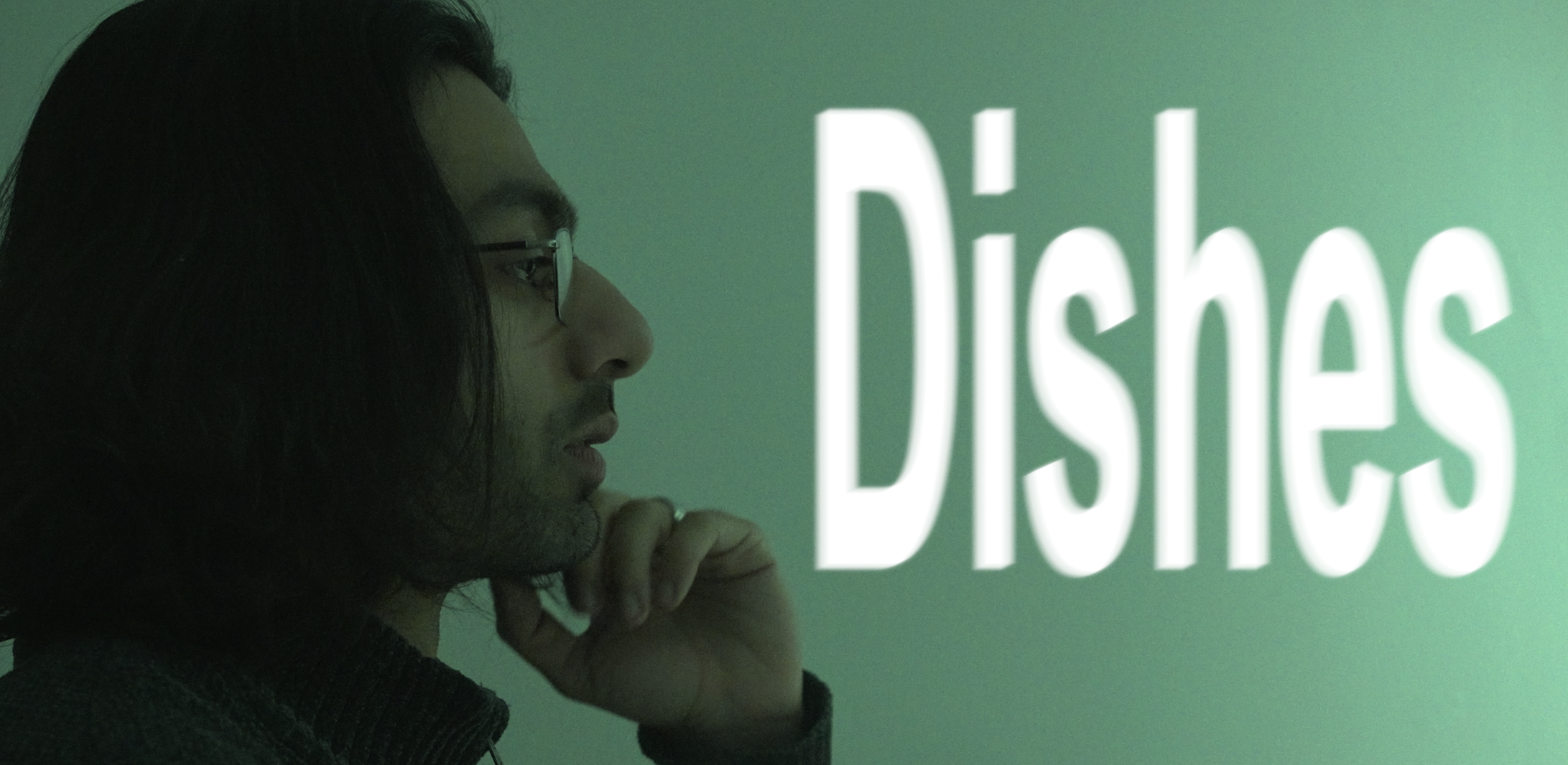 Side profile of a man with long dark hair and glasses looking at a screen that displays the word 'Diseases' in large white text.